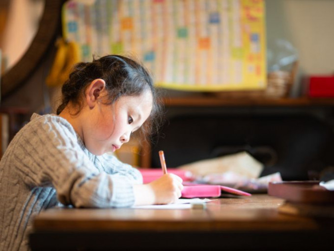 Niña japonesa que está estudiadno