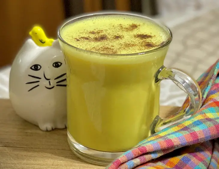 taza con bebida caliente de color amarillo llamada leche dorada con canela