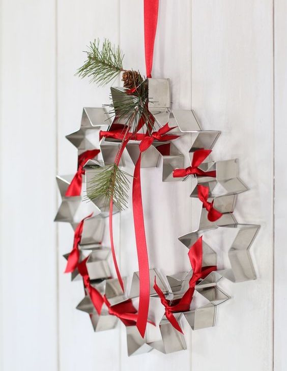 adorno navideño colgado en la puerta hecho con moldes para galletas en forma de estrella 