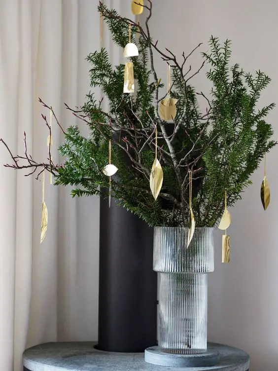 jarrón con ramas de pino y adornos navideños
