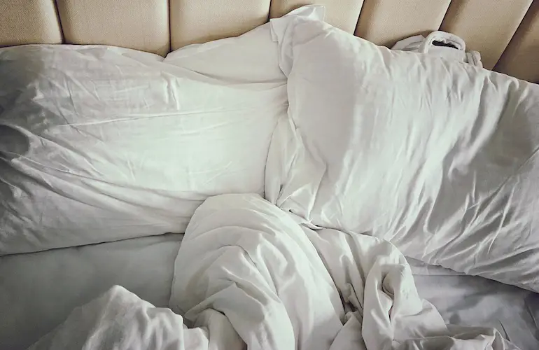 sábanas y almohadas blancas en cama