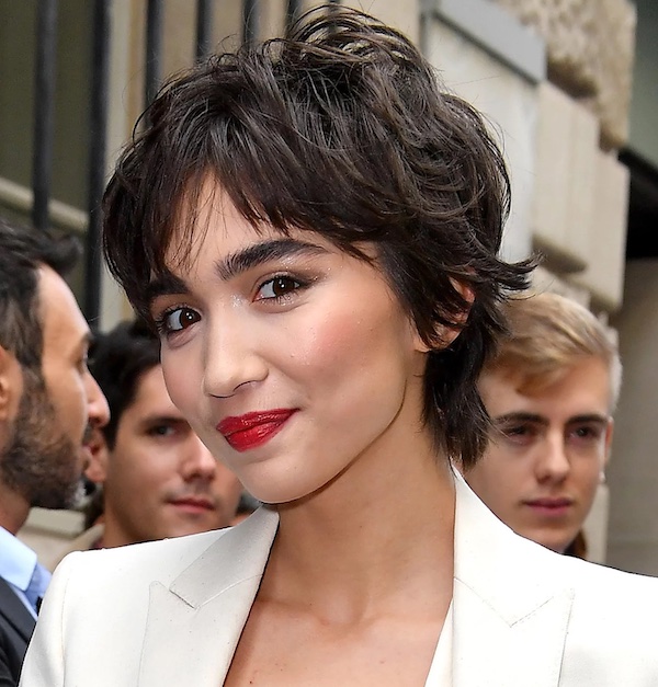 mujer sonrendo 
con pelo corto negro blazer blanco