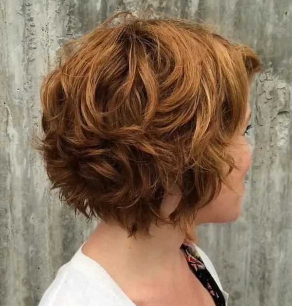 mujer de perfil pelo rojo y corto blusa blanca