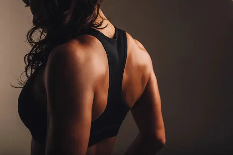 espalda de mujer de tez morena con top deportivo negro