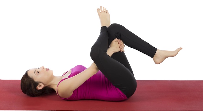 mujer acostada en el piso postura de paloma reclinada yoga 