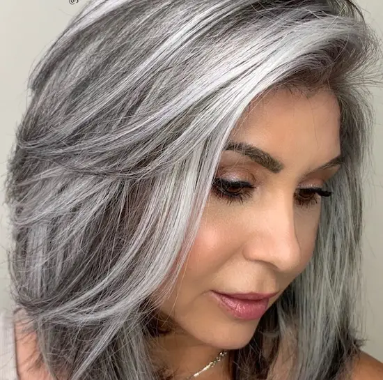 mujer con canas y highlights pelo estilo lob