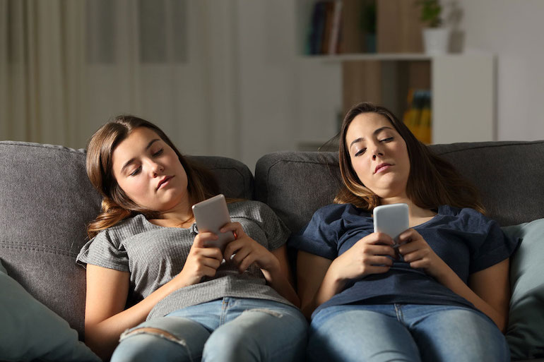 dos adolescentes viendo el celular