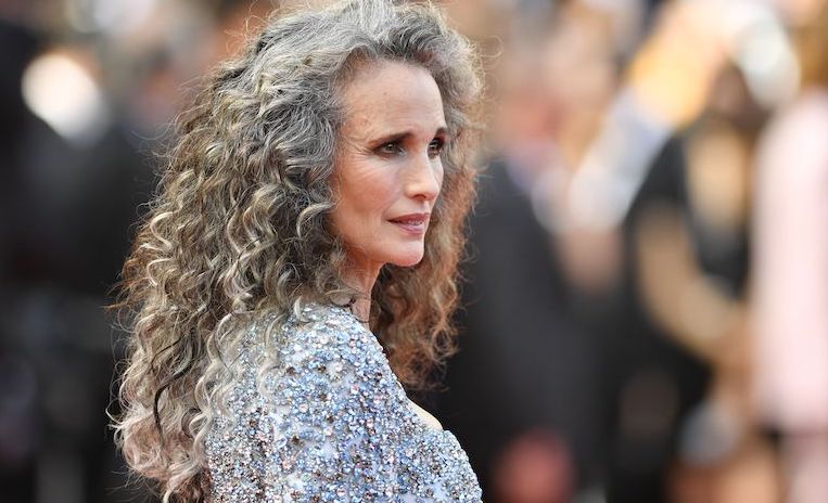 mujer con pelo canoso y ondulado vestido brilloso de gala