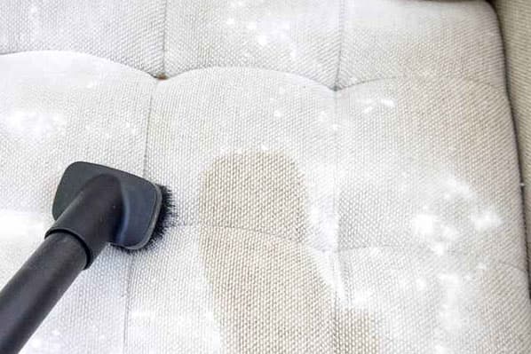 Limpiando la tela del sofá que está manchada