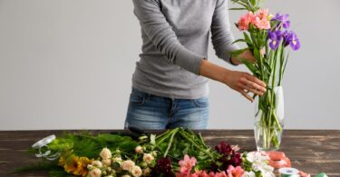 Mujer cuidando sus flores para que duren más tiempo en el jarrón