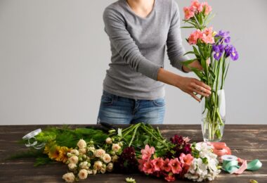 Mujer cuidando sus flores para que duren más tiempo en el jarrón