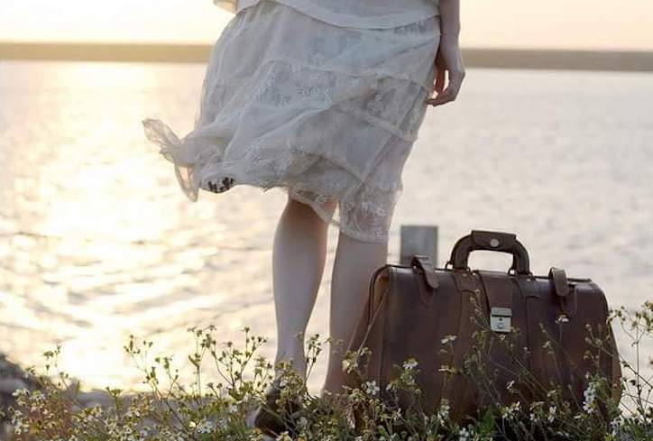 piernas de mujer orilla de un río maleta piernas de mujer con medias blancas y vestido