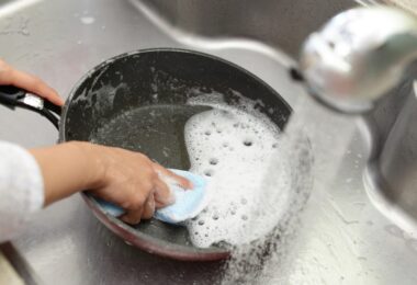 Lavando sartén bajo agua