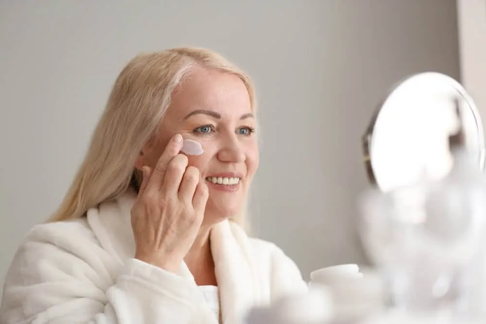 Mujer se aplica crema antiarrugas
